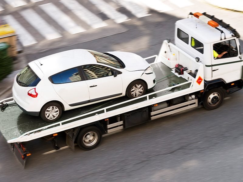 Guincho rebocando hatch branco em movimento