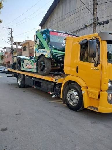 Guincho amarelo transportando carro de corrida